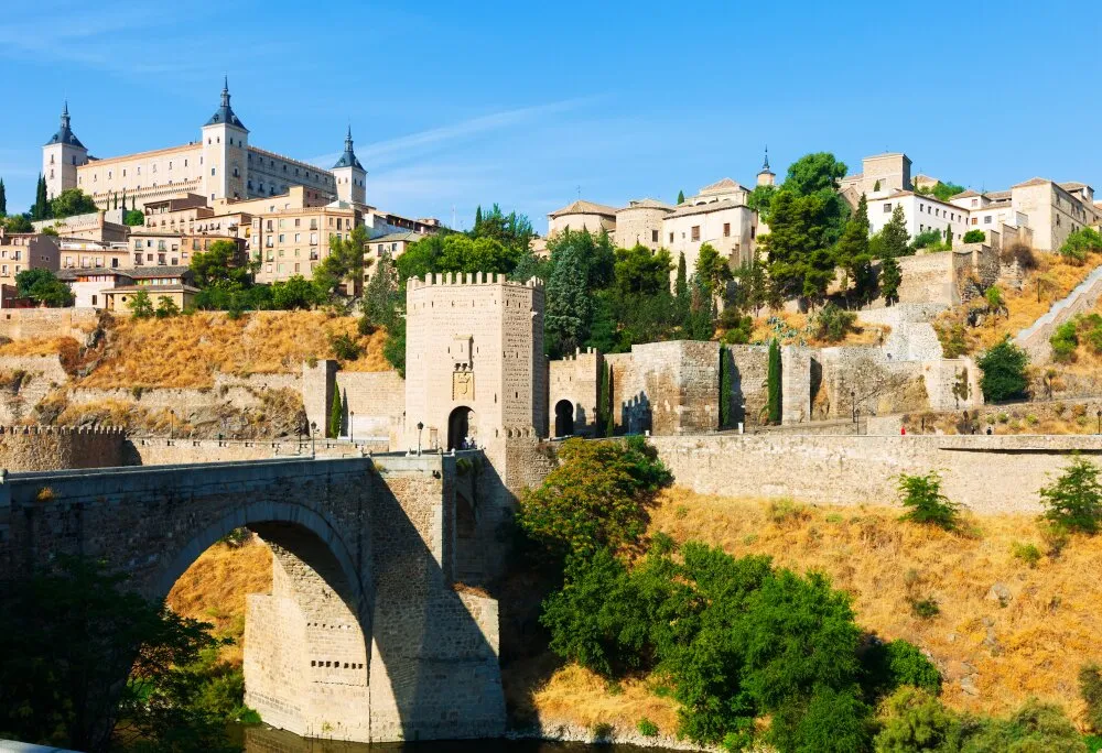 Toledo, historisk spansk stad med Alcázar och medeltida bro, exempel på städer med ZBE-zoner