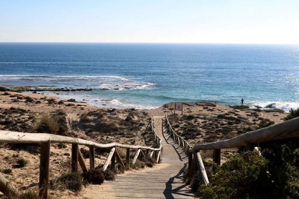 Träpasserel som leder ner till en öde strand i Cabo de Gata naturpark